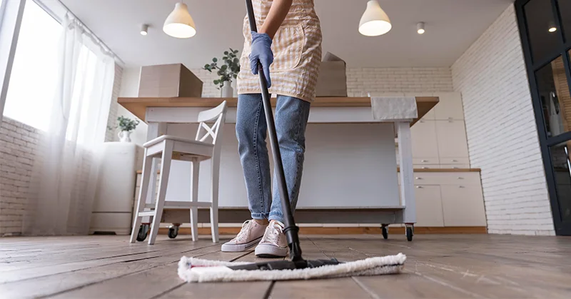 تصویر خانم در حال تی کشیدن کف خانه برای پاسخ به سوال خانه تکانی را از کجا شروع کنیم